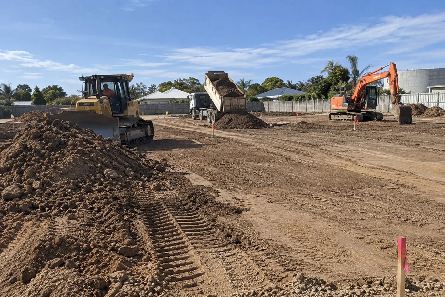 Dozer, excavator and tipper truck carrying out bulk earthworks on a Mackay site